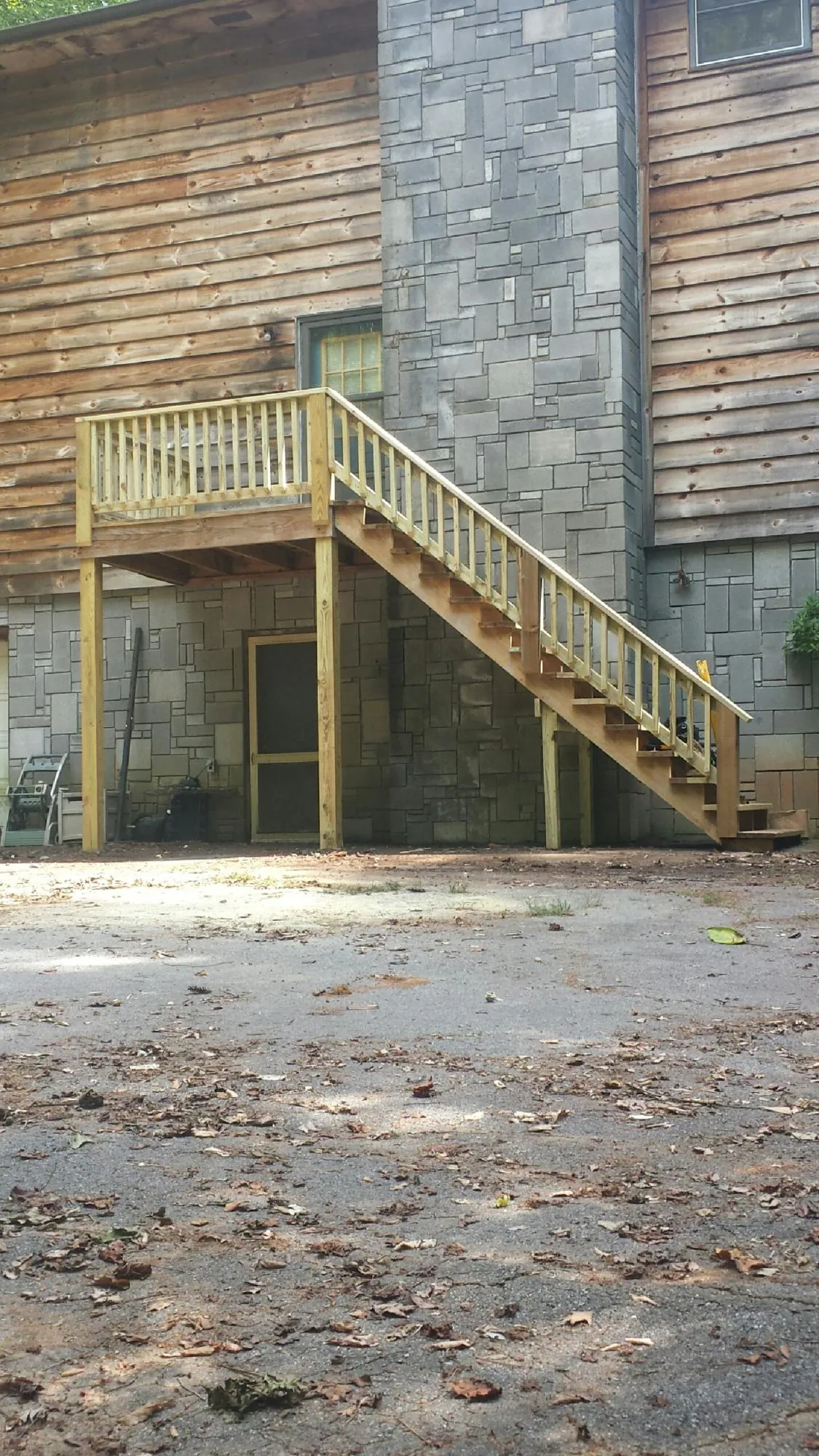 New pressure treated deck and stair landing on a log home in Carlisle
