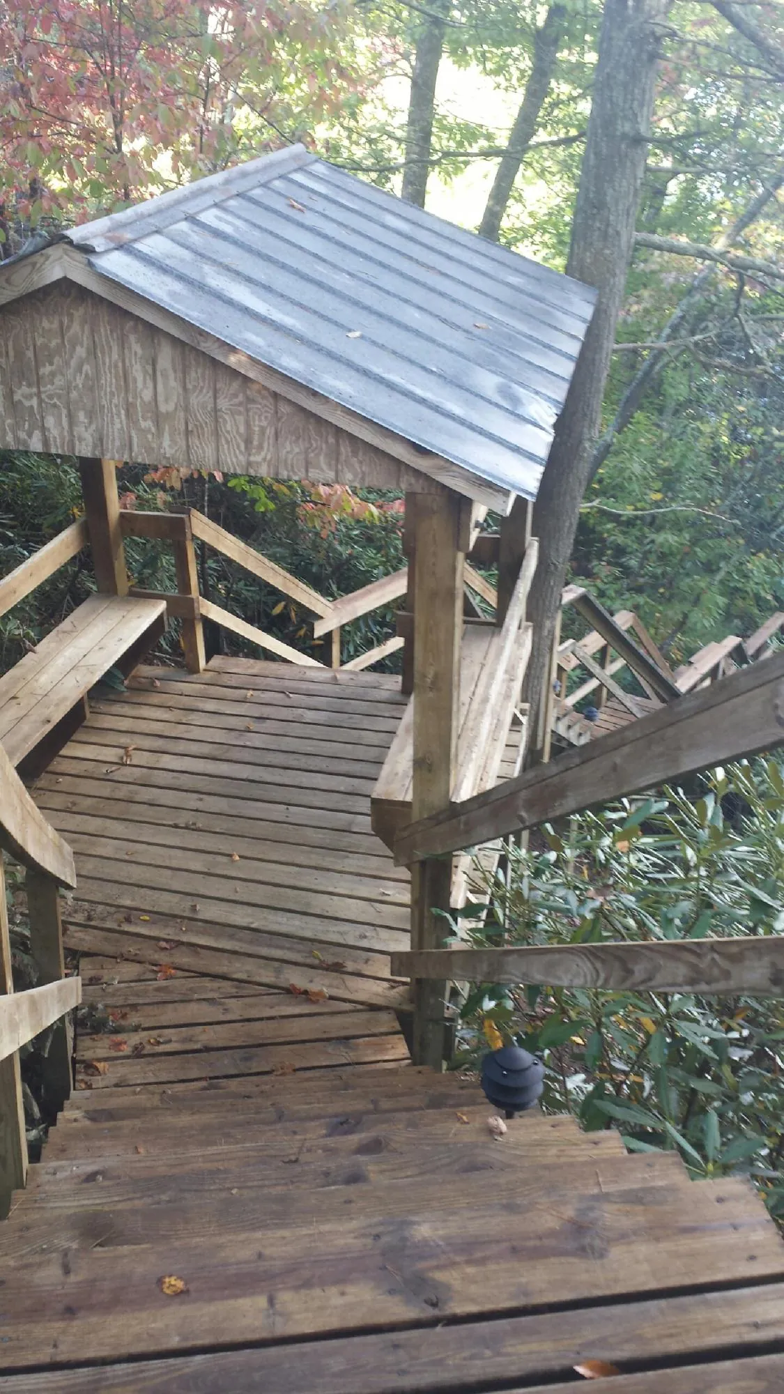 Metal roofed shelter over wooden steps on a wooded walkway — Skylight Repair & Installation work by our crew in Carlisle